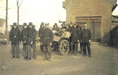 erstes Gruppenbild der Leegebrucher Feuerwehr:Das erste Einsatzgerät: der hartgummibereifte Anhängewagen. Die erste Wehr in Leegebruch nach ihrer Gründung. Ganz rechts: Otto Federwisch, Mitte Vordergrund: Gustav Krumpa