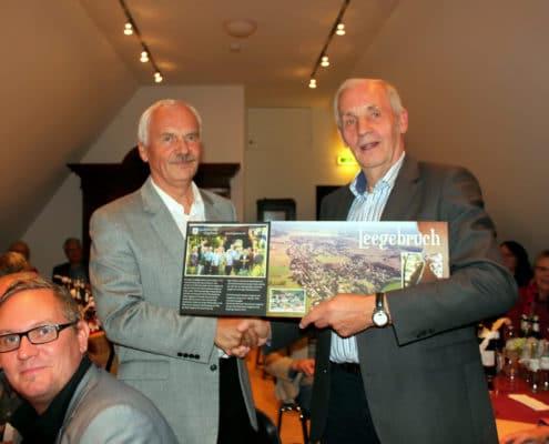 Der Geschichtsvereinsvorsitzende Dr. Norbert Rohde überreicht dem Vorsitzenden des befreundeten Heimatvereins, Dr. Alois Thomes, ein Gastgeschenk.