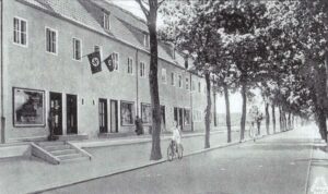 Blick auf die 1940 komplett fertiggestellte und vollständig bezogene Verkaufszeile in der Eichenallee. Auch in den Läden dieser Verkaufseinrichtung haben Zwangsarbeiter unterschiedlicher Nationalitäten Zwangsarbeit geleistet.